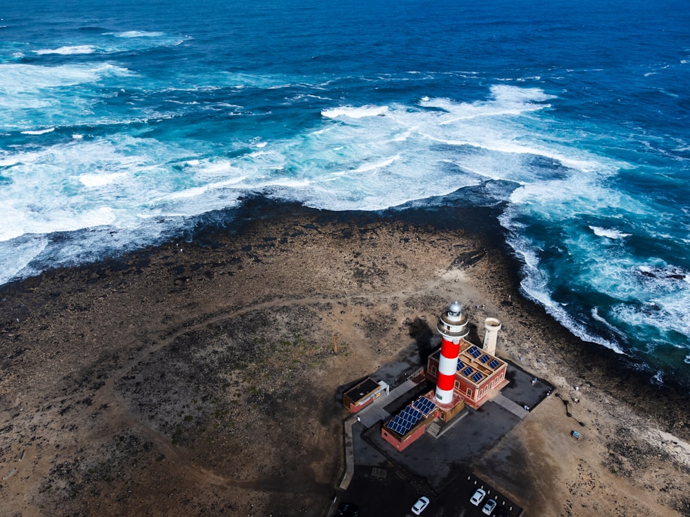 an aerial view of a lighthouse near the ocean