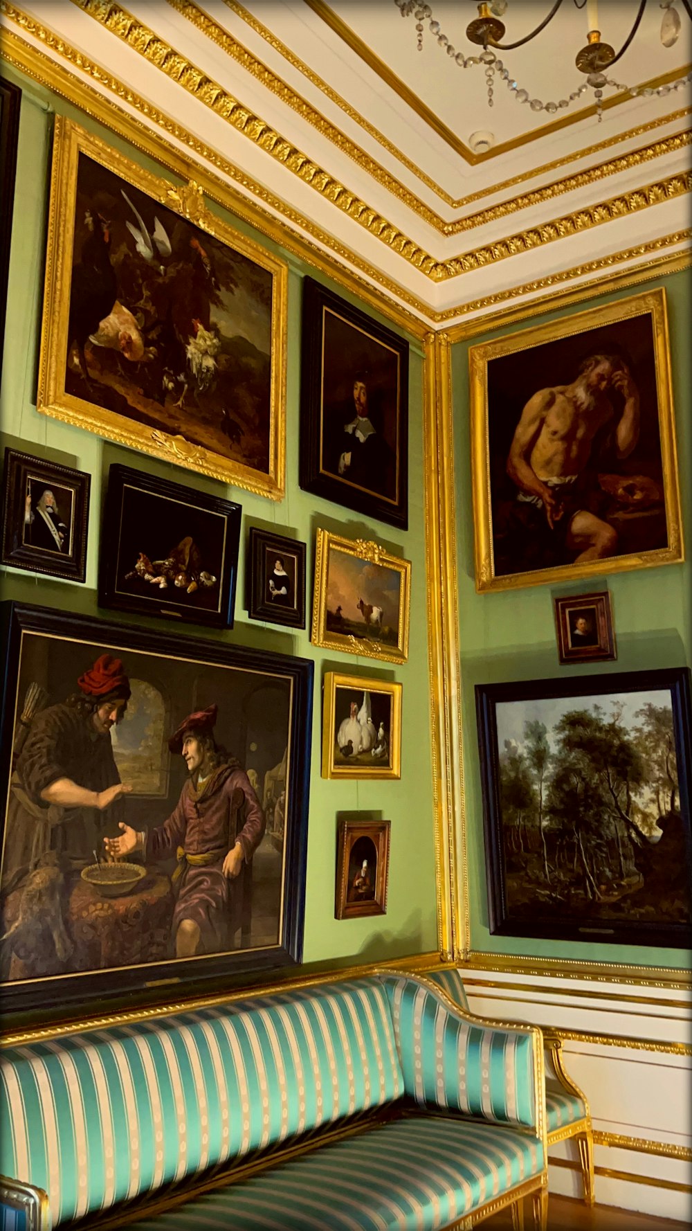 壁にたくさんの絵画や絵画が飾られた部屋