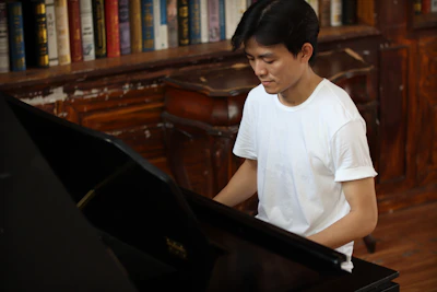 A student smiling while learning piano, seated in a cozy room with natural textures and ivory whites.