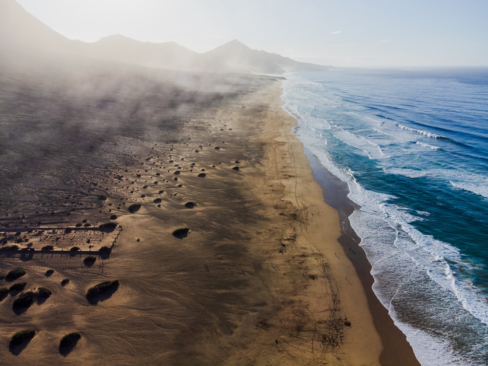 an aerial view of a sandy beach and ocean