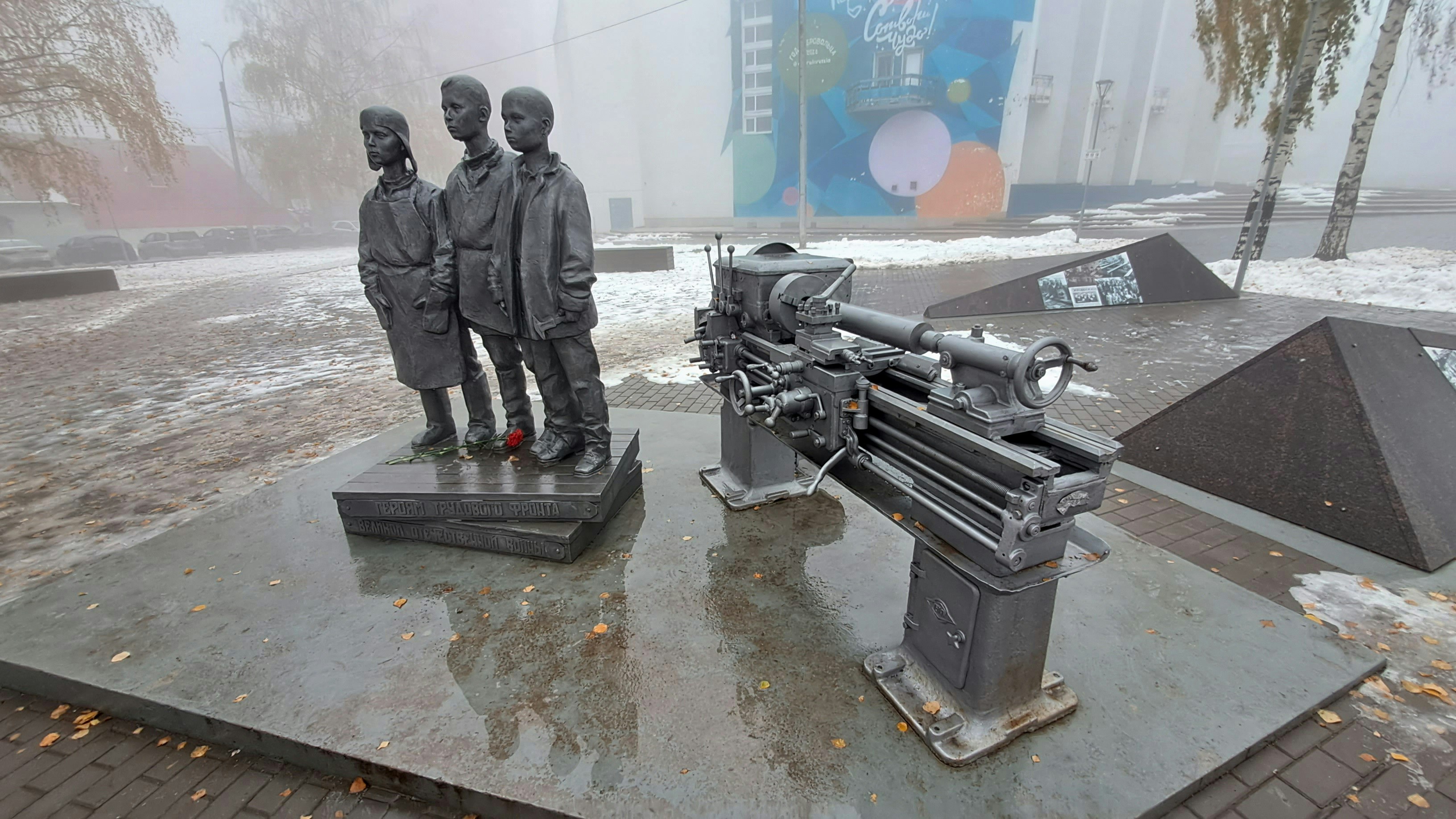a group of statues of men standing next to a machine