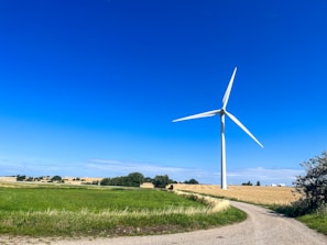 Wind turbine setup in a rural area with clear skies.