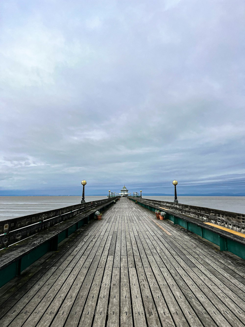 a long wooden pier with a light pole on top of it
