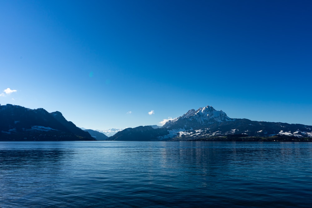 a large body of water with mountains in the background