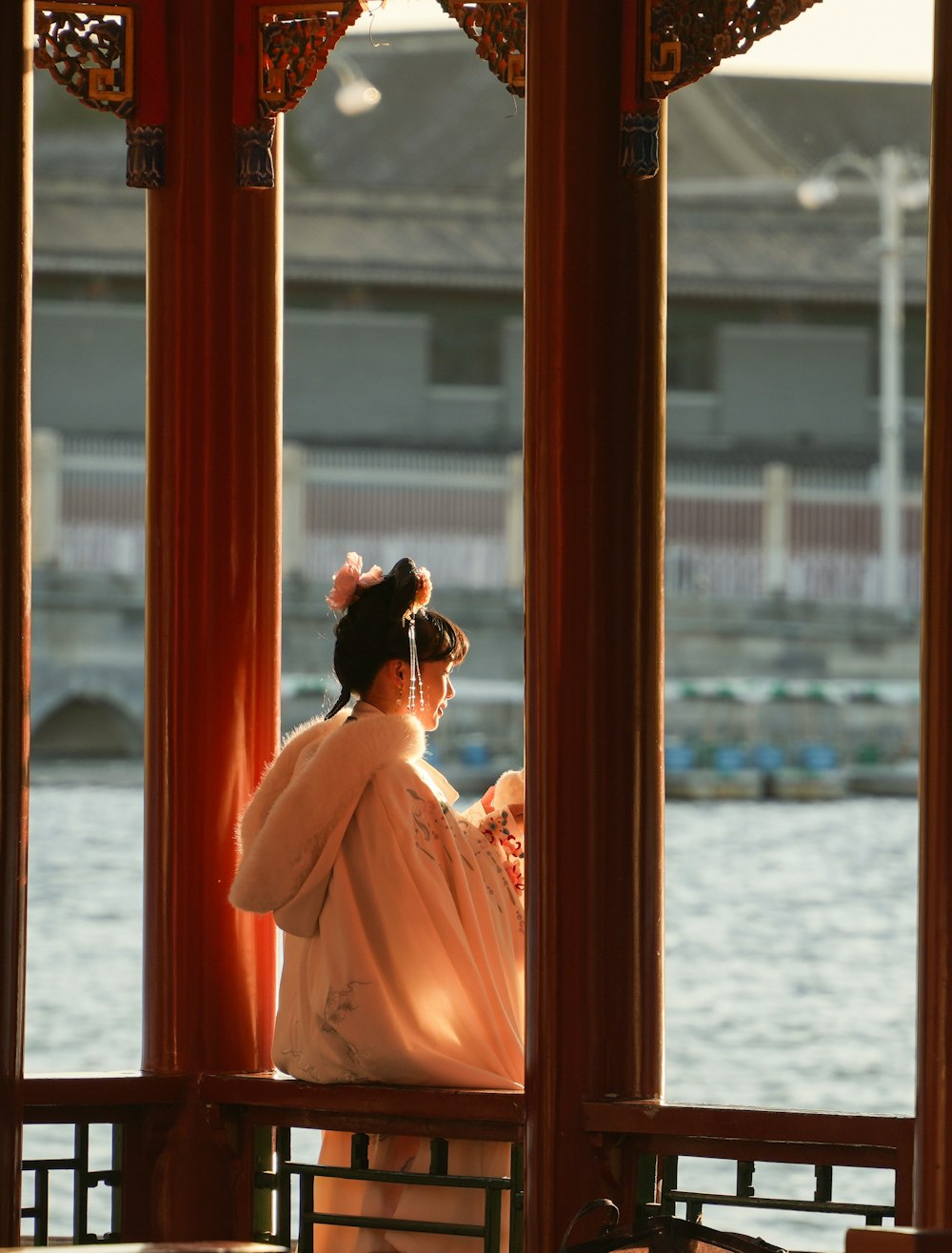 a woman in a kimono sitting on a bench