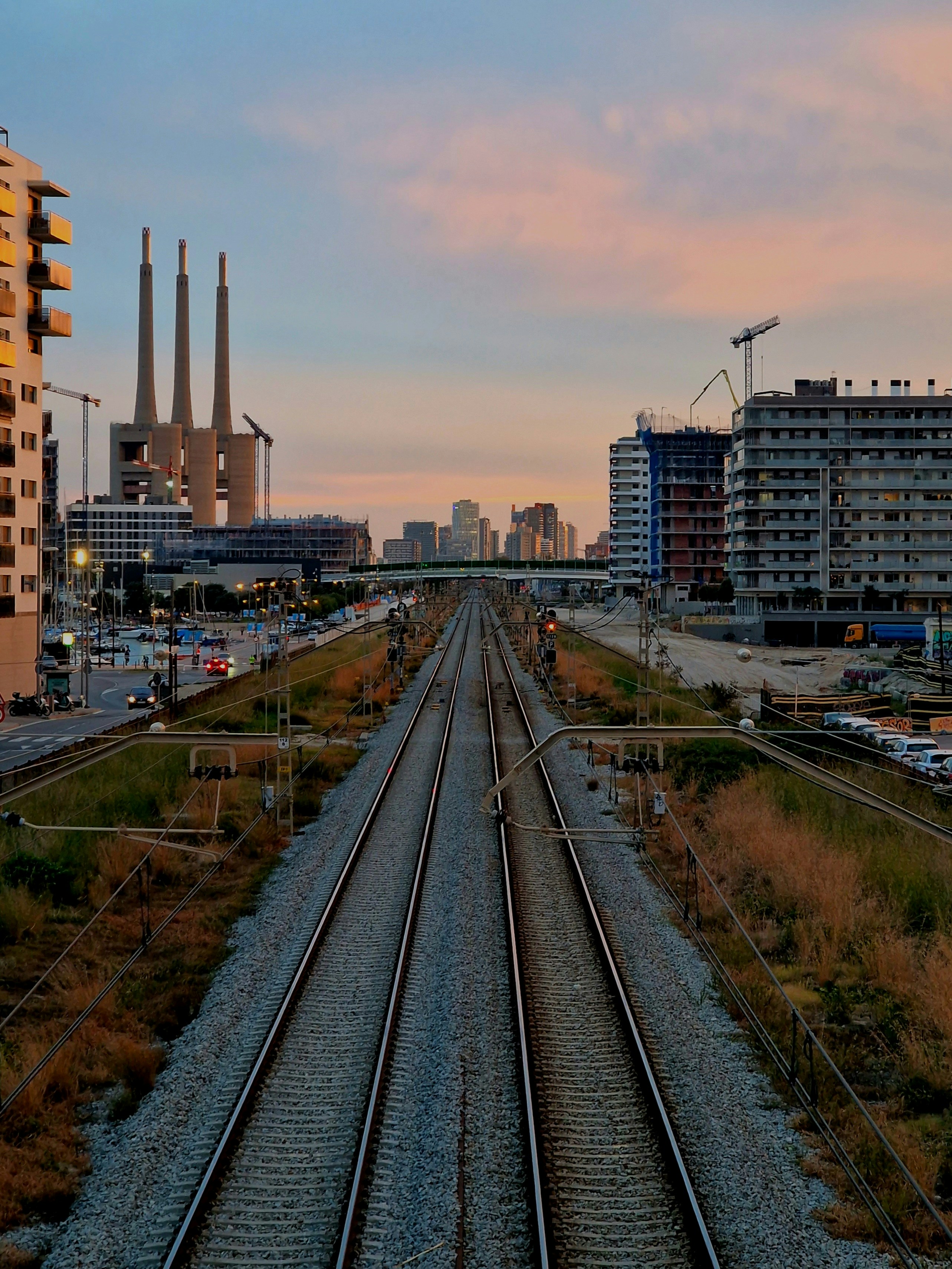 a train track running through a city with tall buildings in the background