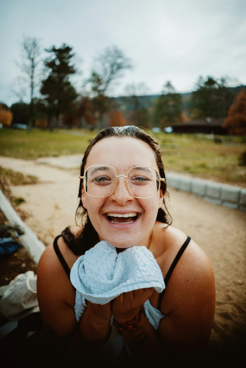 a woman with glasses and a towel in her hand