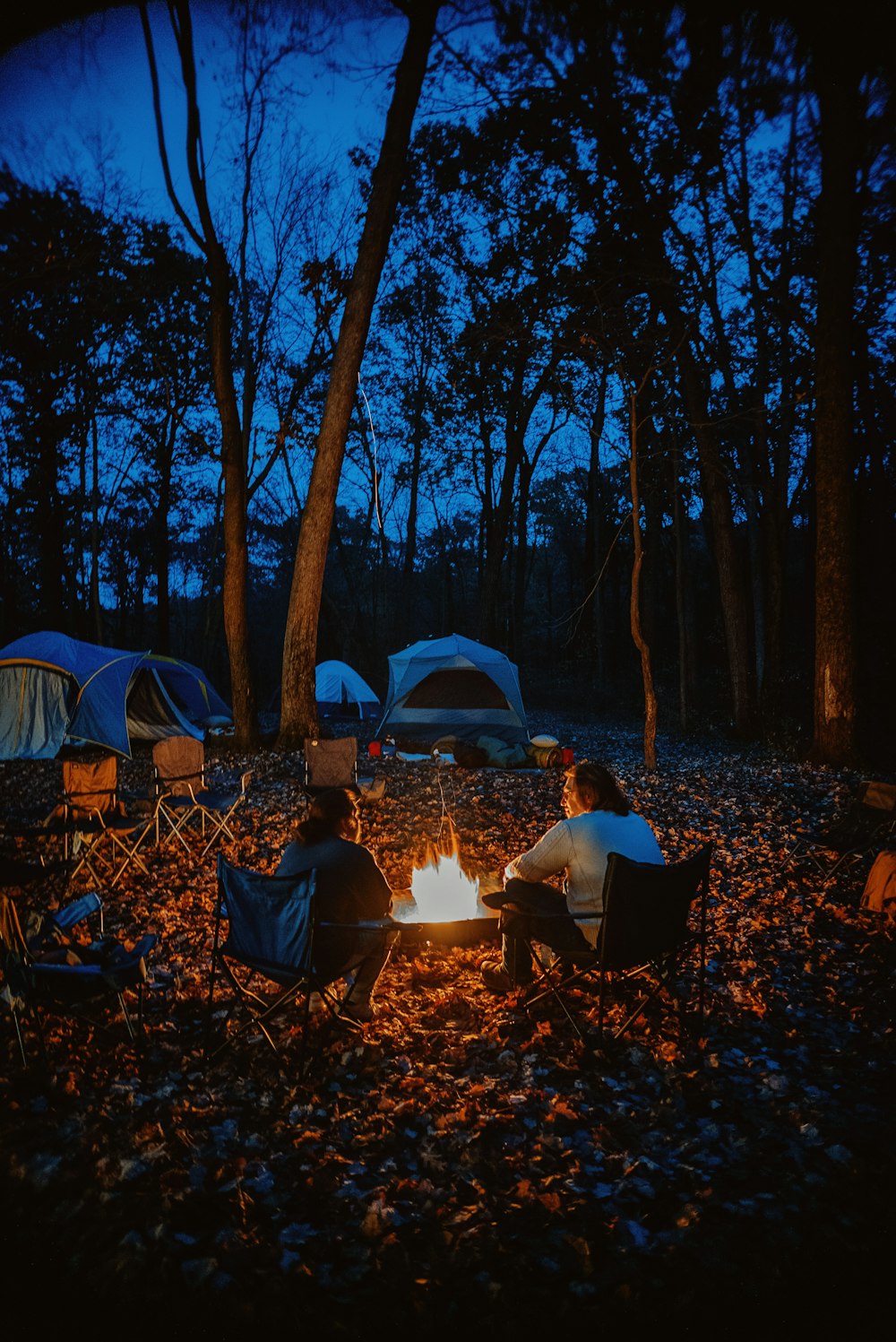 eine Gruppe von Menschen, die um ein Lagerfeuer sitzen