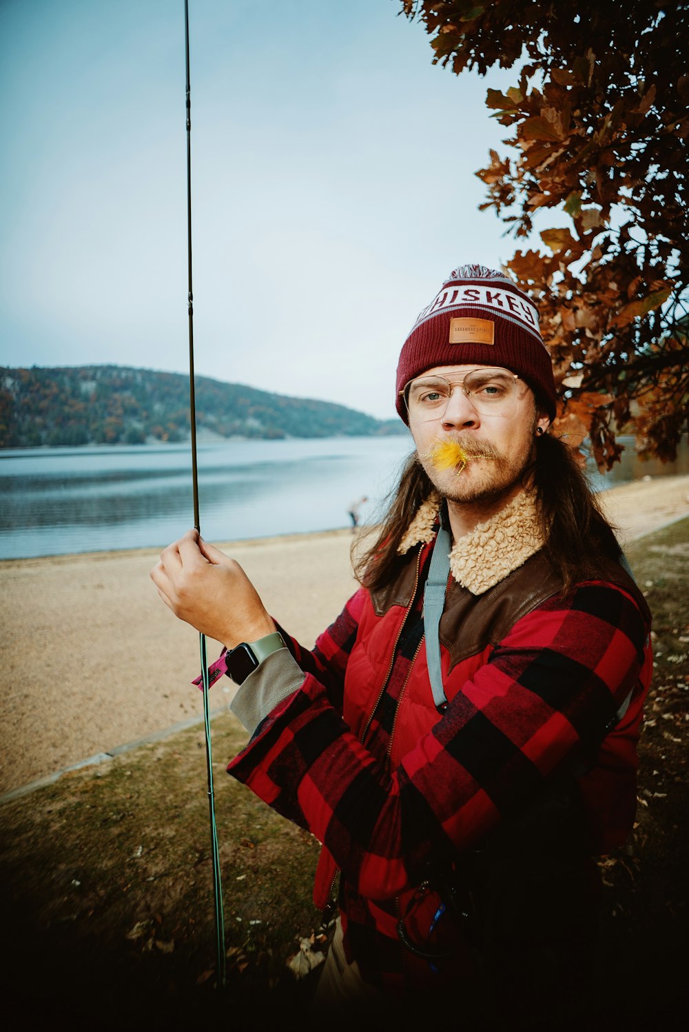a man with long hair holding a fishing pole