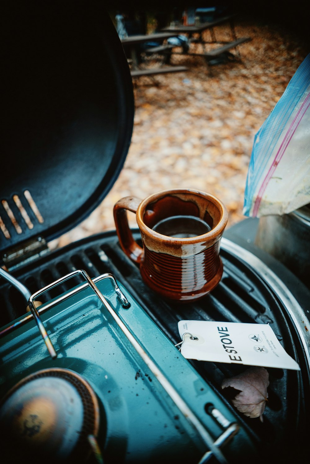 a cup of coffee sitting on top of a grill