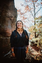 a woman standing in front of a rock formation