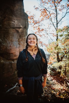a woman standing in front of a rock formation