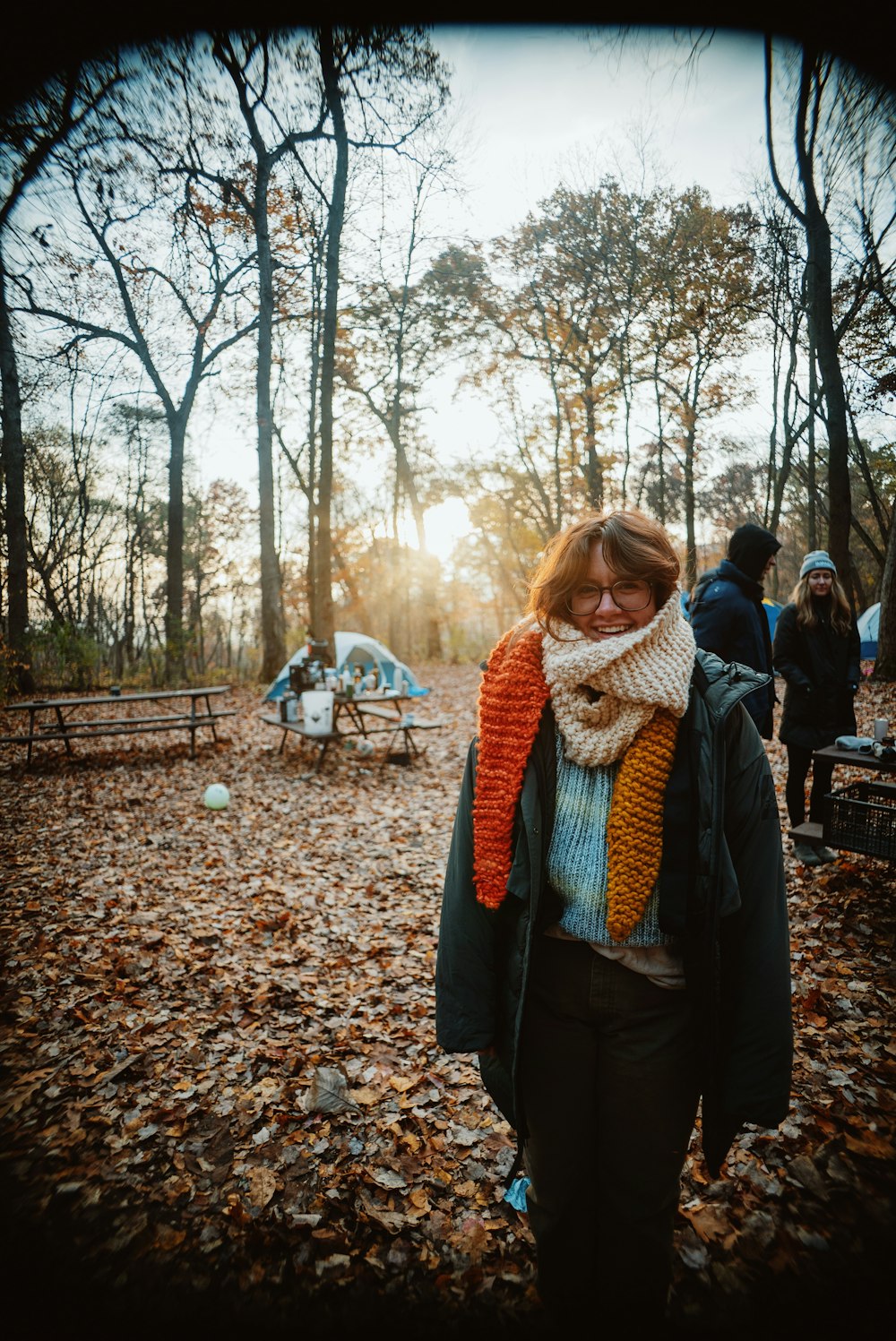 a woman wearing a scarf standing in the woods