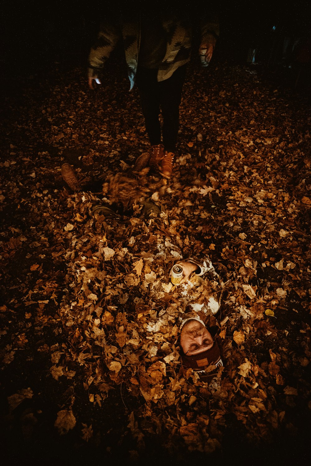 uma pessoa em pé no meio de uma pilha de folhas