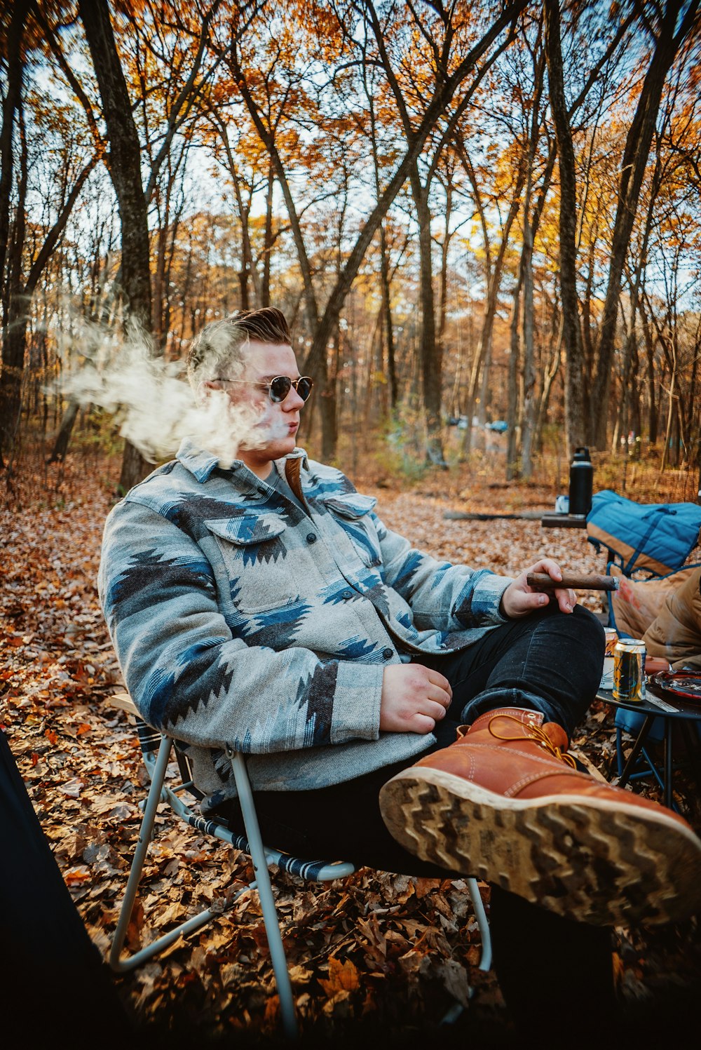 um homem sentado em uma cadeira com um cigarro na boca