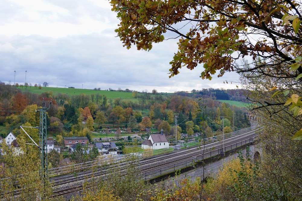 a train traveling down tracks next to a lush green hillside