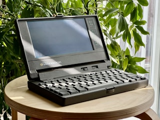 a laptop computer sitting on top of a wooden table