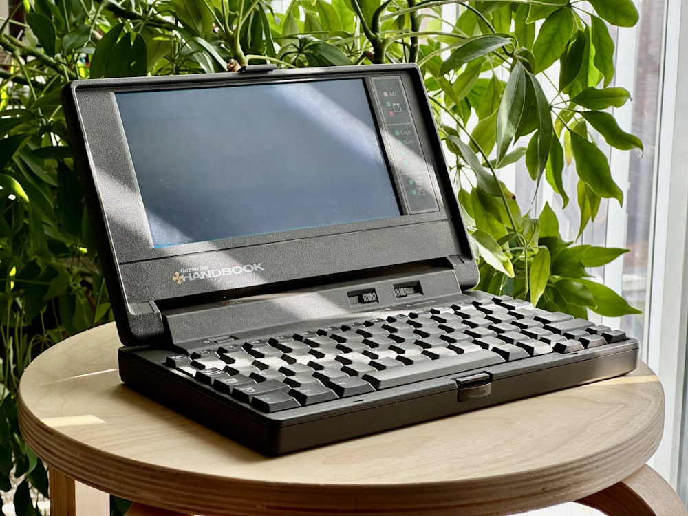 a laptop computer sitting on top of a wooden table