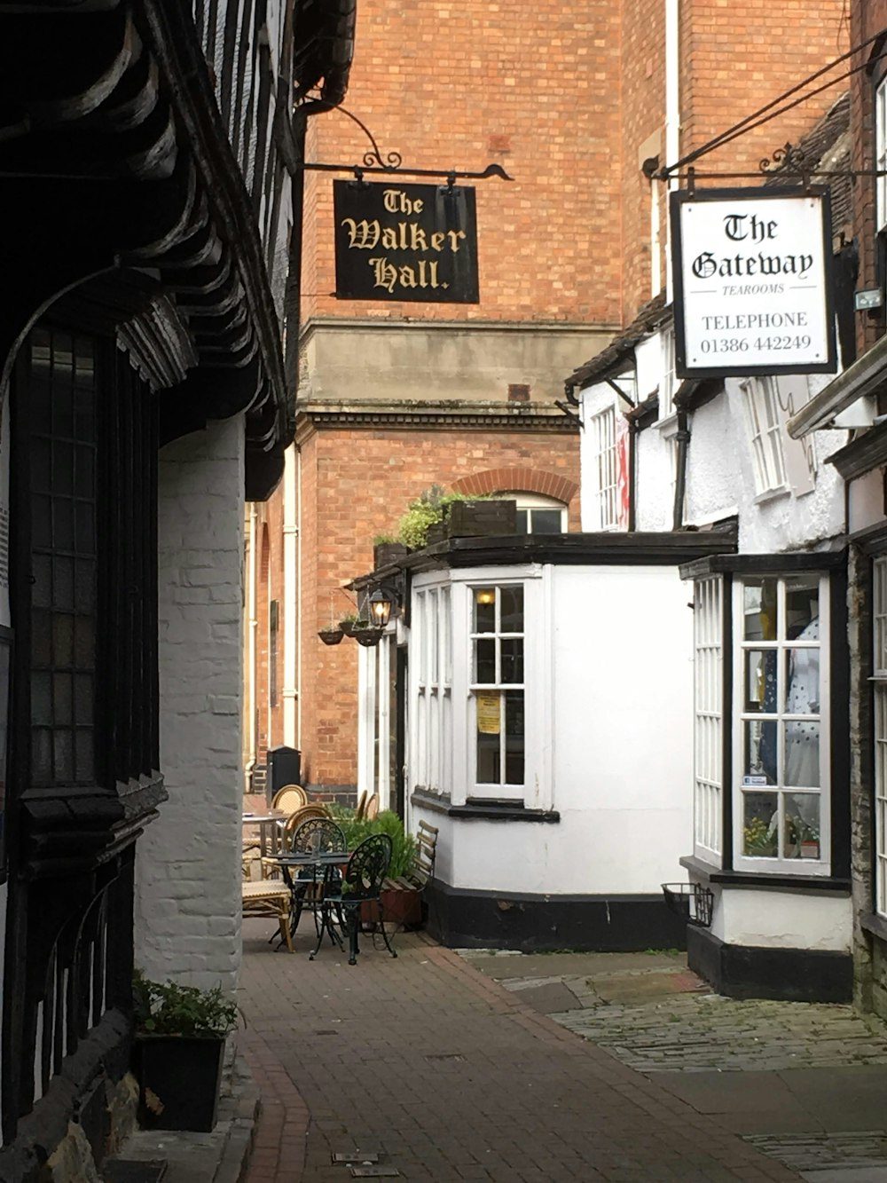 a cobblestone street with a brick building in the background