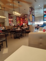 The restaurant’s interior featuring large dinosaur murals and themed lighting.