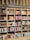 A bookshelf filled with a variety of books categorized under Ibero-American literature. The shelves are organized with books displayed upright and stacked, showcasing colorful covers and titles. The structure is wooden with sections divided by horizontal and vertical beams.