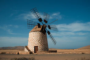 a windmill sitting in the middle of a desert