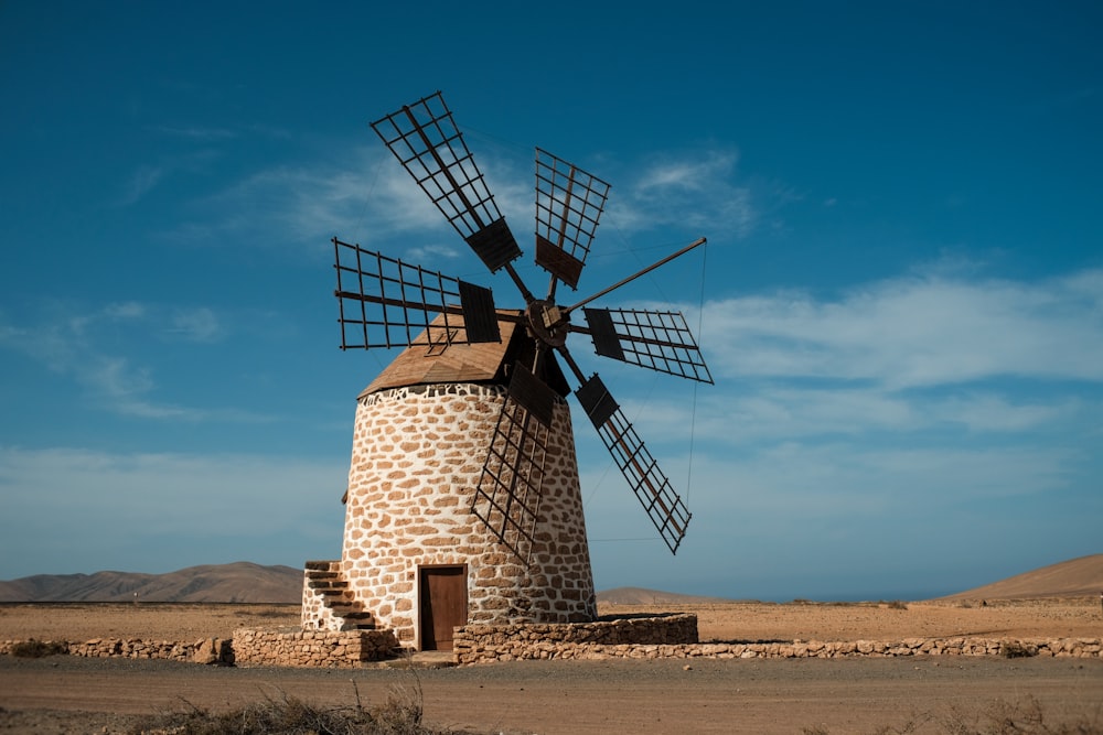 a windmill sitting in the middle of a desert
