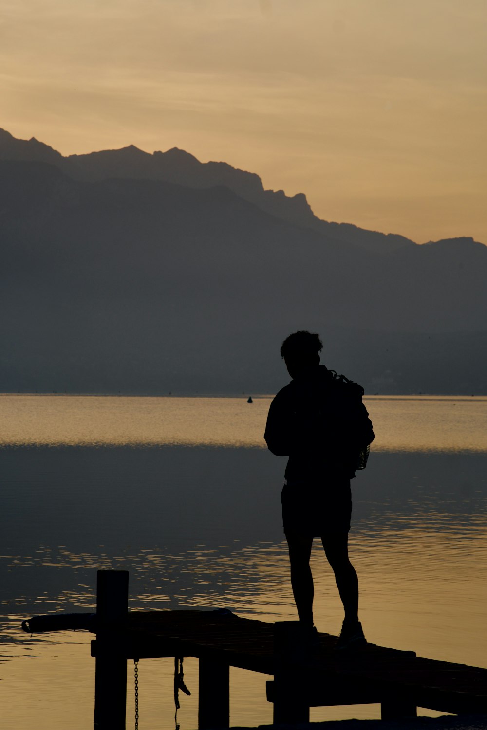 a person standing on a dock with a backpack