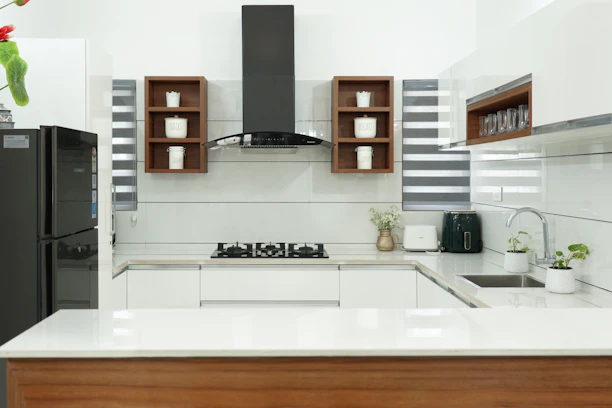 A sleek kitchen setup featuring modern household gadgets on a clean white countertop.