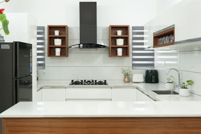 Modern black matte kitchen with a custom parrilla and sleek ventilation hood.