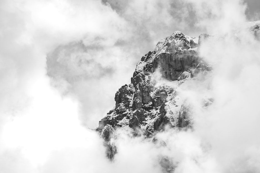 Une photo en noir et blanc d’une montagne dans les nuages