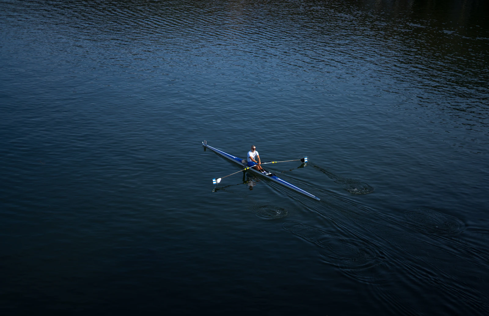 Overhead view of a single scull on still water