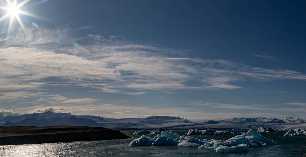 a group of icebergs floating on top of a body of water