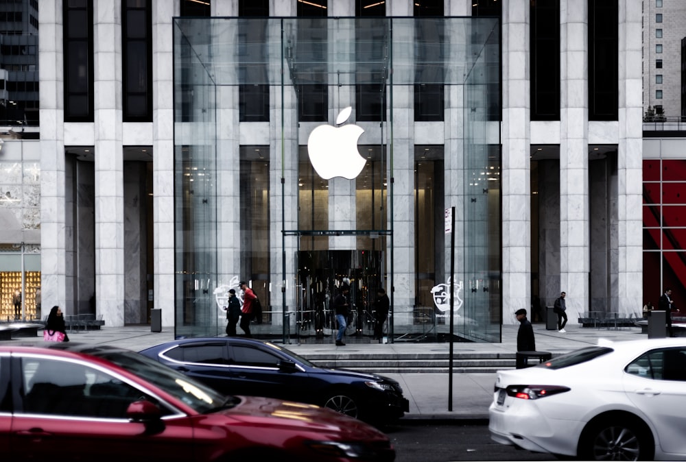 a group of cars parked in front of an apple store