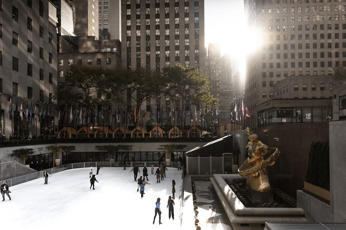 Des gens qui patinent sur une patinoire extérieure en ville