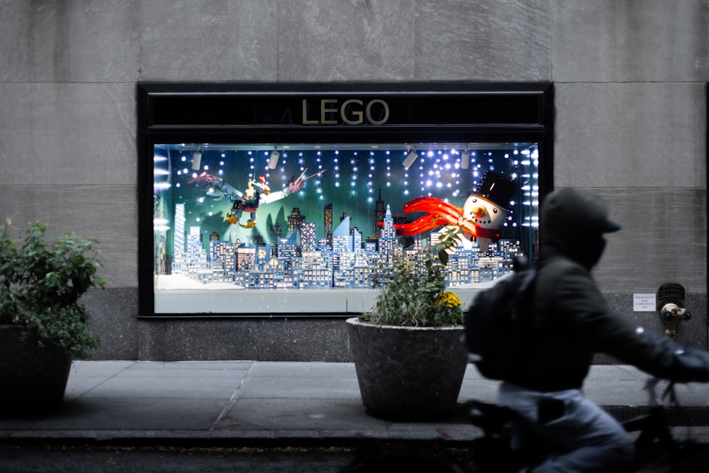 a man riding a motorcycle past a window display