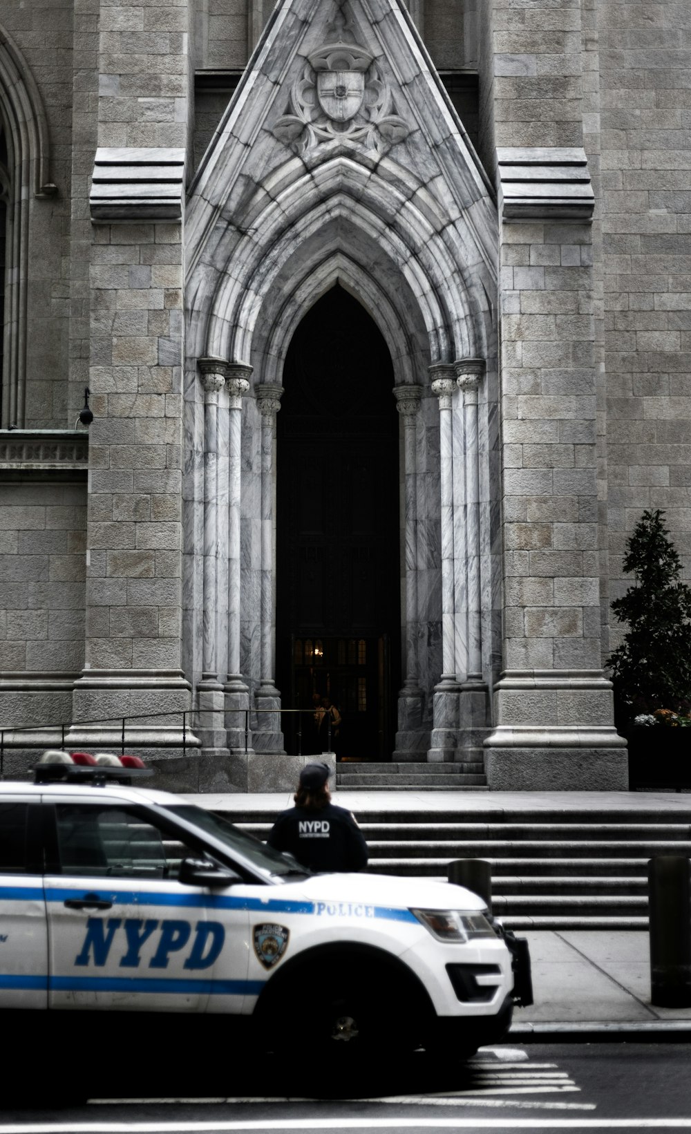 a police car parked in front of a large building