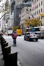 A busy city street with various modes of transportation including cars, buses, and bicycles.