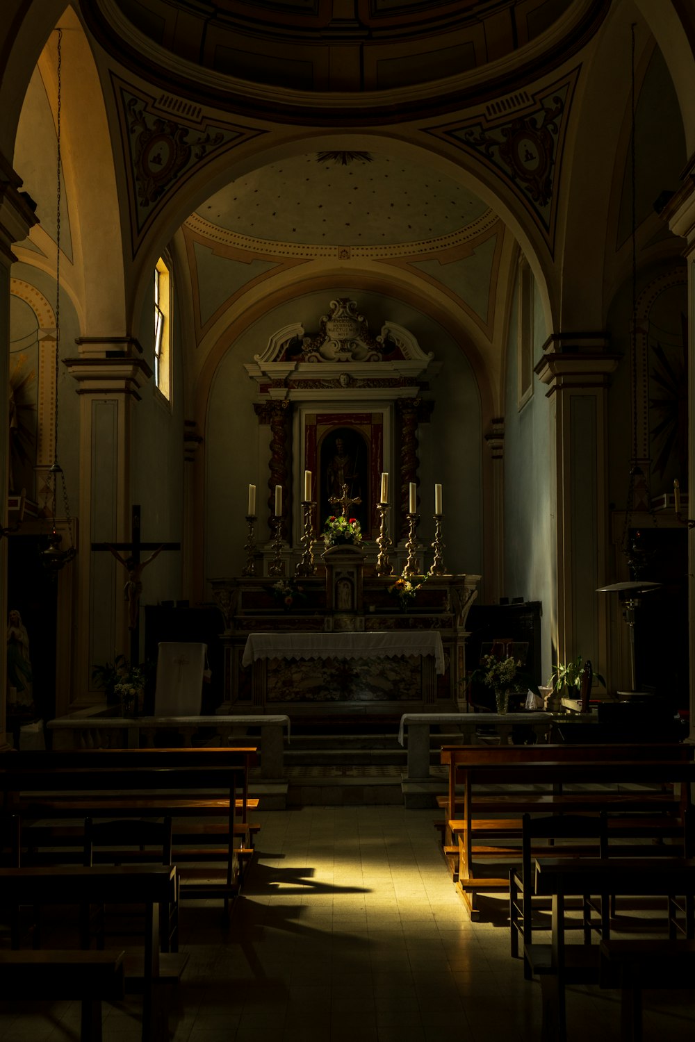 a dimly lit church with pews and a alter