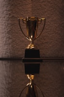 A close-up of a trophy surrounded by sports equipment, representing victory and achievement.