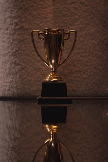 A shimmering crystal trophy engraved with 'Luxury Motel Awards' resting on a polished wooden table.