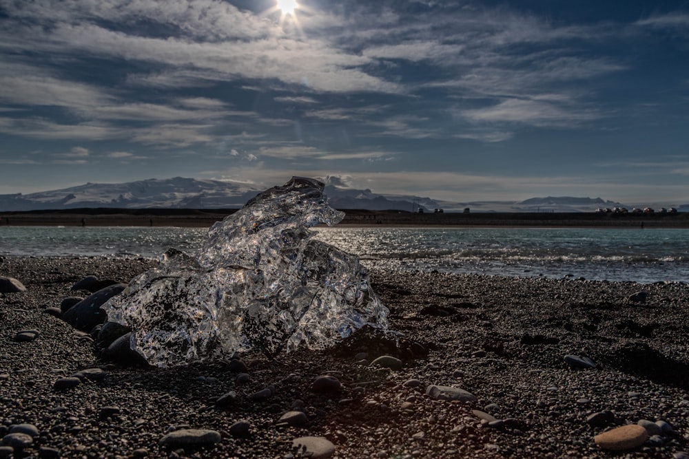 una gran roca sentada en la parte superior de una playa rocosa