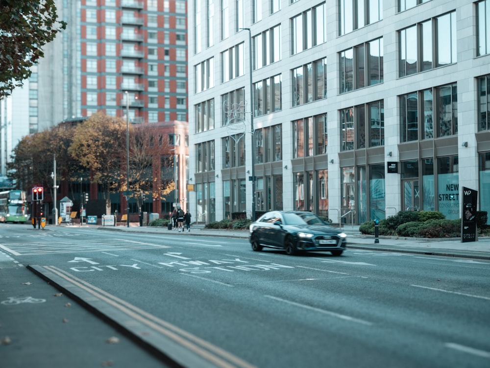 a car driving down a city street next to tall buildings