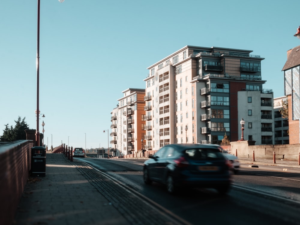 a car driving down a street next to tall buildings