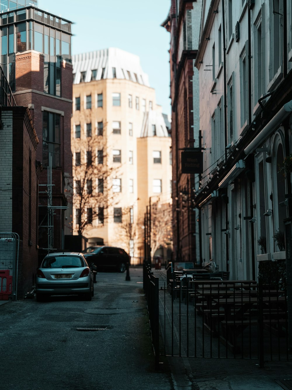 a car parked on the side of a street next to tall buildings