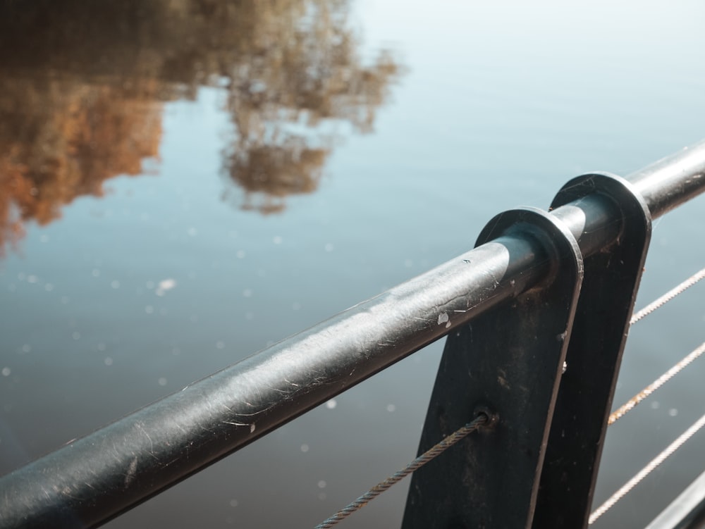 a metal railing next to a body of water