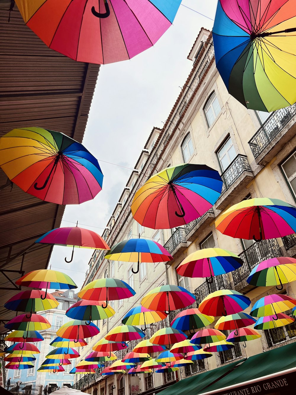 a group of colorful umbrellas hanging from a building