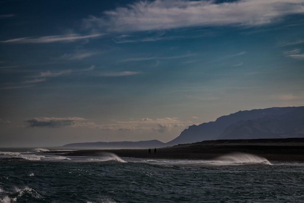 a body of water with a mountain in the background