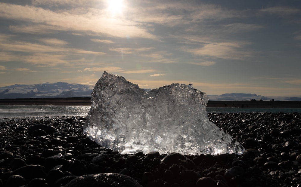 a large iceberg sitting on top of a rocky beach