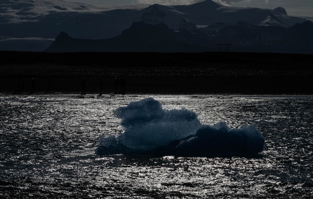 a large iceberg floating in the middle of a lake